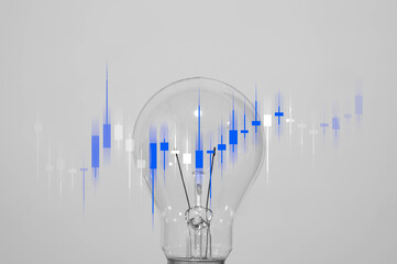 A glowing light bulb with candlestick chart overlay symbolizes financial insight, stock trading strategy, and innovative investment ideas.