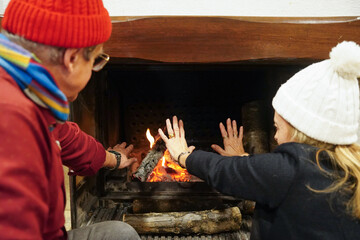 Mature couple by the cozy fireplace in winter