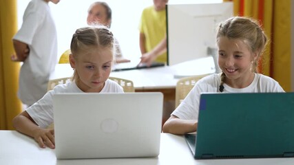 Children using laptop in classroom focusing on learning and education as two student child work on computer and technology while kids collaborate and explore school projects and computer skills - Powered by Adobe