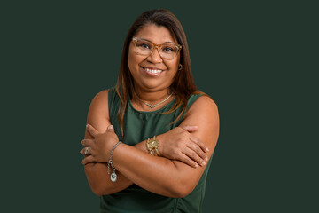 Joyful Woman in Glasses with Crossed Arms on Green Background