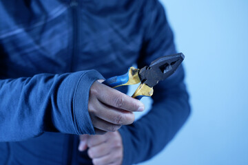 Hand holding pliers . Pliers are workshop equipment specifically used for holding, cutting, removing and installing work materials.
