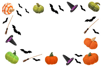 Abstract white background for Halloween holiday decorations in the form of a knitted witch's hat, a broom, black bats and an orange green knitted pumpkin flying in the air. Halloween concept.