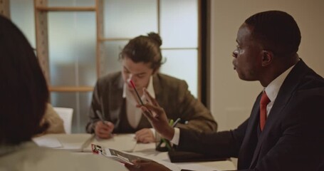 A diverse business team collaborates on a project, engaging in discussions and strategizing. The team works together in their modern office. - Powered by Adobe