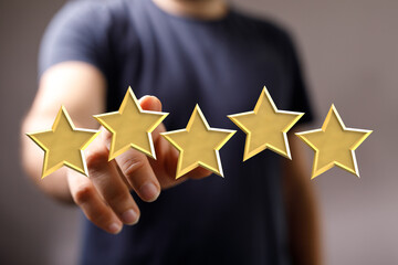 Person highlighting five golden stars. Symbolizing success, excellence, quality, and top rating....