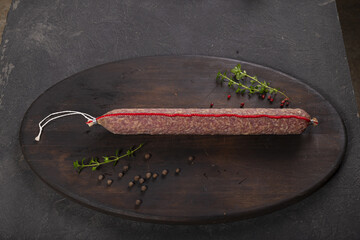 Dry-cured and smoked sausage on a dark background