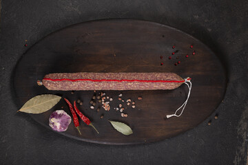 Dry-cured and smoked sausage on a dark background
