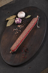 Dry-cured and smoked sausage on a dark background