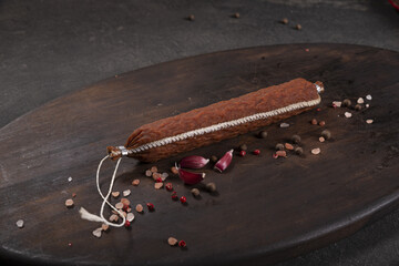 Dry-cured and smoked sausage on a dark background