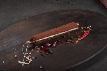 Dry-cured and smoked sausage on a dark background