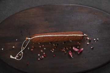 Dry-cured and smoked sausage on a dark background