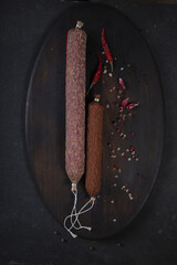 Dry-cured and smoked sausage on a dark background