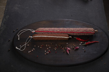 Dry-cured and smoked sausage on a dark background