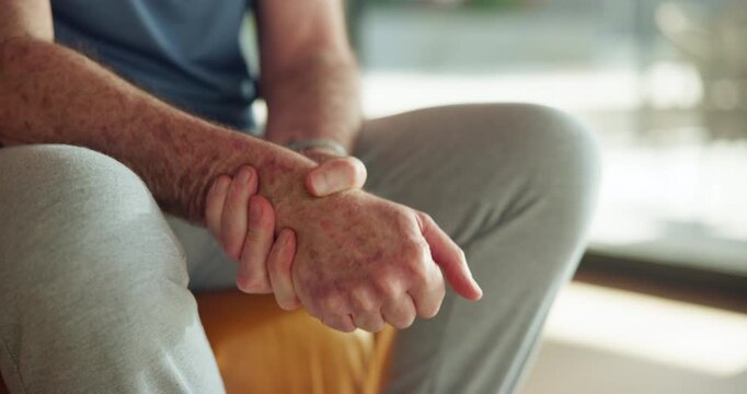 Hands, senior man and wrist pain in home from arthritis, carpal tunnel syndrome and inflammation. Retirement, elderly person and joint massage on sofa for muscle tension, discomfort and fibromyalgia