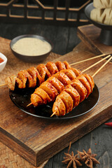 Spicy Handmade Gluten Skewers Shaanxi Chinese Street Food on Wooden Serving Board with Dipping Sauce
