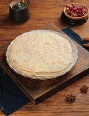 Traditional Asian flatbread pancakes with spices and chili peppers on rustic wooden table