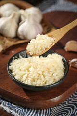 Fresh Shandong Farm Garlic Minced in Wooden Spoon and Bowl with Whole Bulbs on Rustic Wood Surface