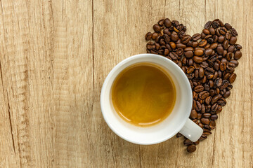 Cup of Coffee with Heart Shape Made of Coffee Beans on Wooden Background