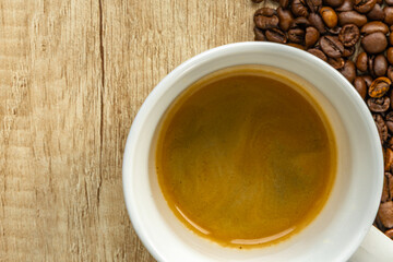 Rising Coffee Prices Concept with Cup and Spilled Coffee Beans on Wooden Table