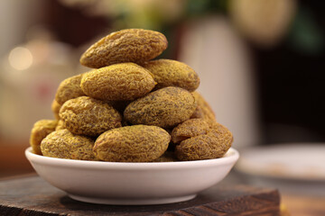 Dried Candied Fruit or Licorice Treats Stacked in White Bowl on Wooden Table