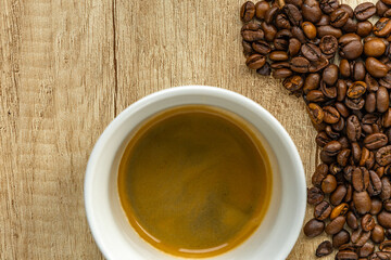 Rising Coffee Prices Concept with Cup and Spilled Coffee Beans on Wooden Table
