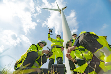 Engineers at a wind farm use a drone for inspection near a wind turbine. The image highlights the use of technology in renewable energy, wind power projects, and modern energy solutions.