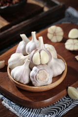 Fresh Shandong Farm Garlic Bulbs and Cloves in Wooden Bowl on Rustic Kitchen Table