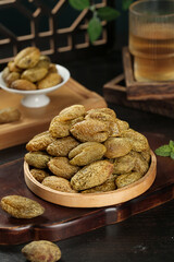 Dried Candied Nuts and Licorice Flavored Snacks in Wooden Bowl with Traditional Tea Setting
