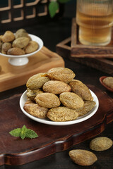 Traditional Chaoshan Dried Preserved Olives and Licorice Fruits on Wooden Plates with Tea Setup