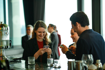 Young entrepreneurs at modern rooftop bar sharing drinks, scanning to pay, and networking, representing global business lifestyle and technology-driven convenience.