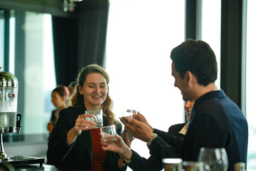 Relaxed business meeting at high-end rooftop bar, showing teamwork, mobile payment technology, and positive social connection in travel and hospitality industry.