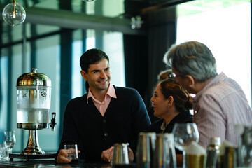 Professional businessmen and women sharing drinks and laughter at modern rooftop bar, illustrating concept of social bonding, relaxation, and business networking.