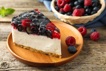 Piece of delicious cheesecake with berries on wooden table, closeup