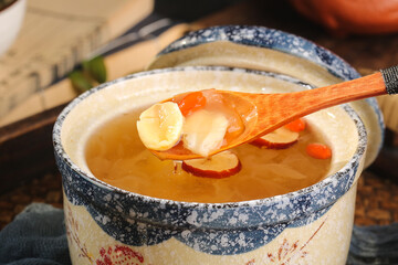Asian Lotus Seed and Silver Fungus Soup in Traditional Ceramic Bowl with Wooden Spoon