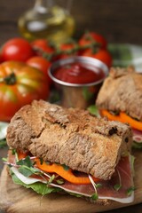 Tasty ciabatta sandwiches served on wooden table, closeup