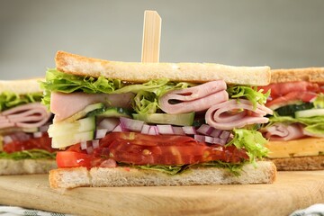 Tasty sandwiches with ham and vegetables on table, closeup