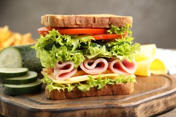 Tasty sandwich with ham, cheese and vegetables on table, closeup
