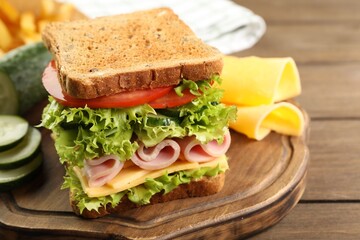 Tasty sandwich with ham, cheese and vegetables on wooden table, closeup