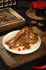 Spicy Glazed Duck Head Chinese Delicacy with Star Anise and Chili Peppers on White Plate