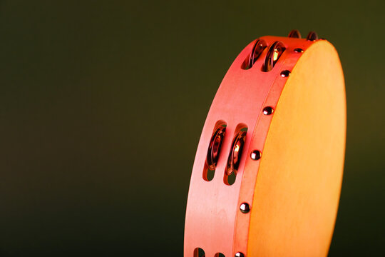 Tambourine on olive background, closeup. Space for text