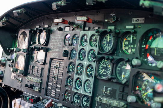The cockpit of a helicopter is filled with gauges and controls. The pilot is in control of the aircraft and must be able to read and interpret the various gauges and indicators to ensure a safe flight