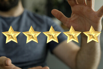 Person's hand reaching up to five gold stars, symbolizing highest rating or excellent customer...