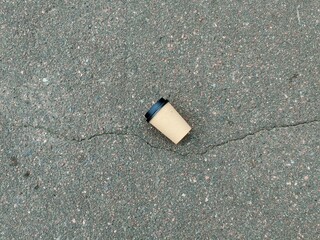 Coffee paper cup on the asphalt, closeup of photo