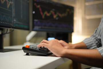 Cropped photo of businessman analyzing business diagram, marketing statistics and finance market graphs on computer monitor in the office.