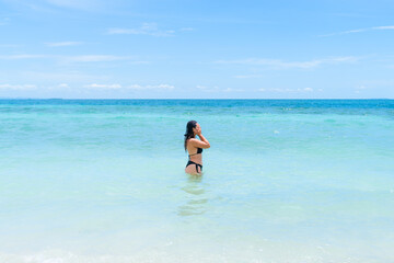 Colombian woman rinsing face with crystal-clear sea water in Mucura Island, Colombian Caribbean