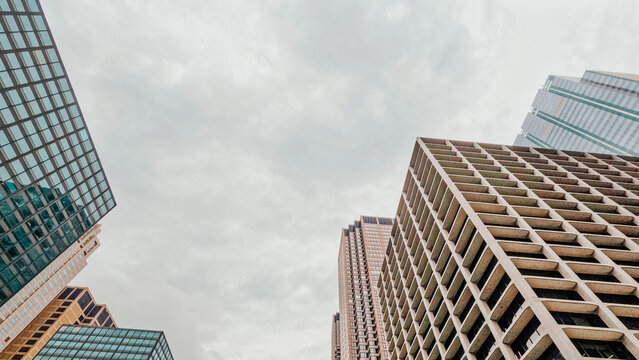 Low angle partial view of iconic skyscraper building architecture in downtown Chicago, Illinois. Set against a soft cloudy sky. - Powered by Adobe