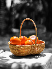 Oranges in a basket on a table with a green grass background