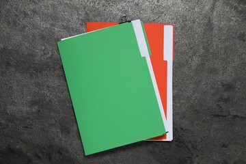 Many documents in folders on grey textured table, top view