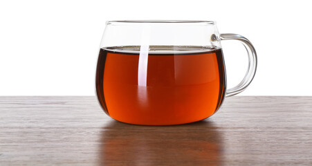 Cup of aromatic black tea on wooden table against white background