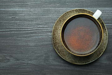 Aromatic black tea in cup on wooden table, top view. Space for text