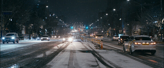 Snowy Boulevard at Night with Car Light Trails